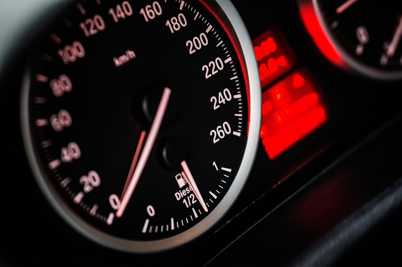 Close-up of a car's speedometer and a red-lit display in the instrument cluster
