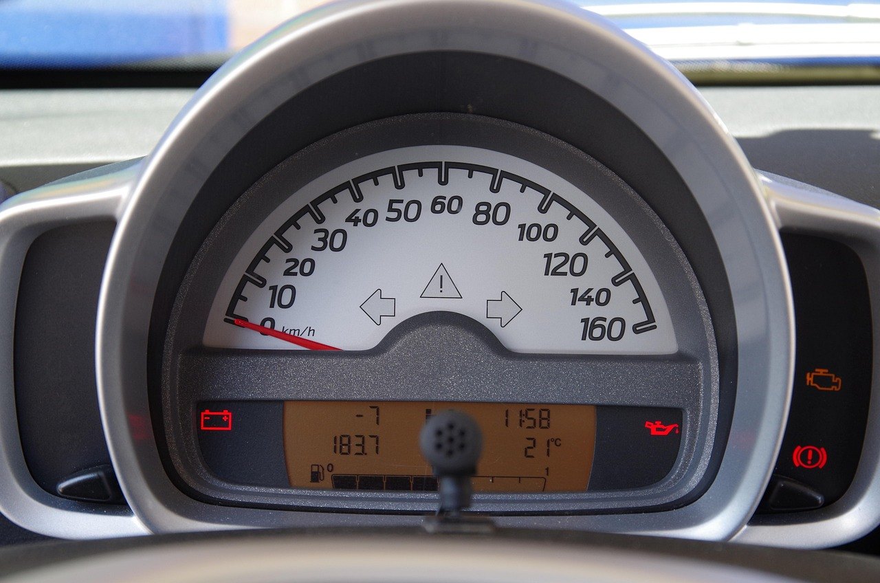 A car's instrument cluster with several warning lamps lit, including an amber engine outline at the right-hand side